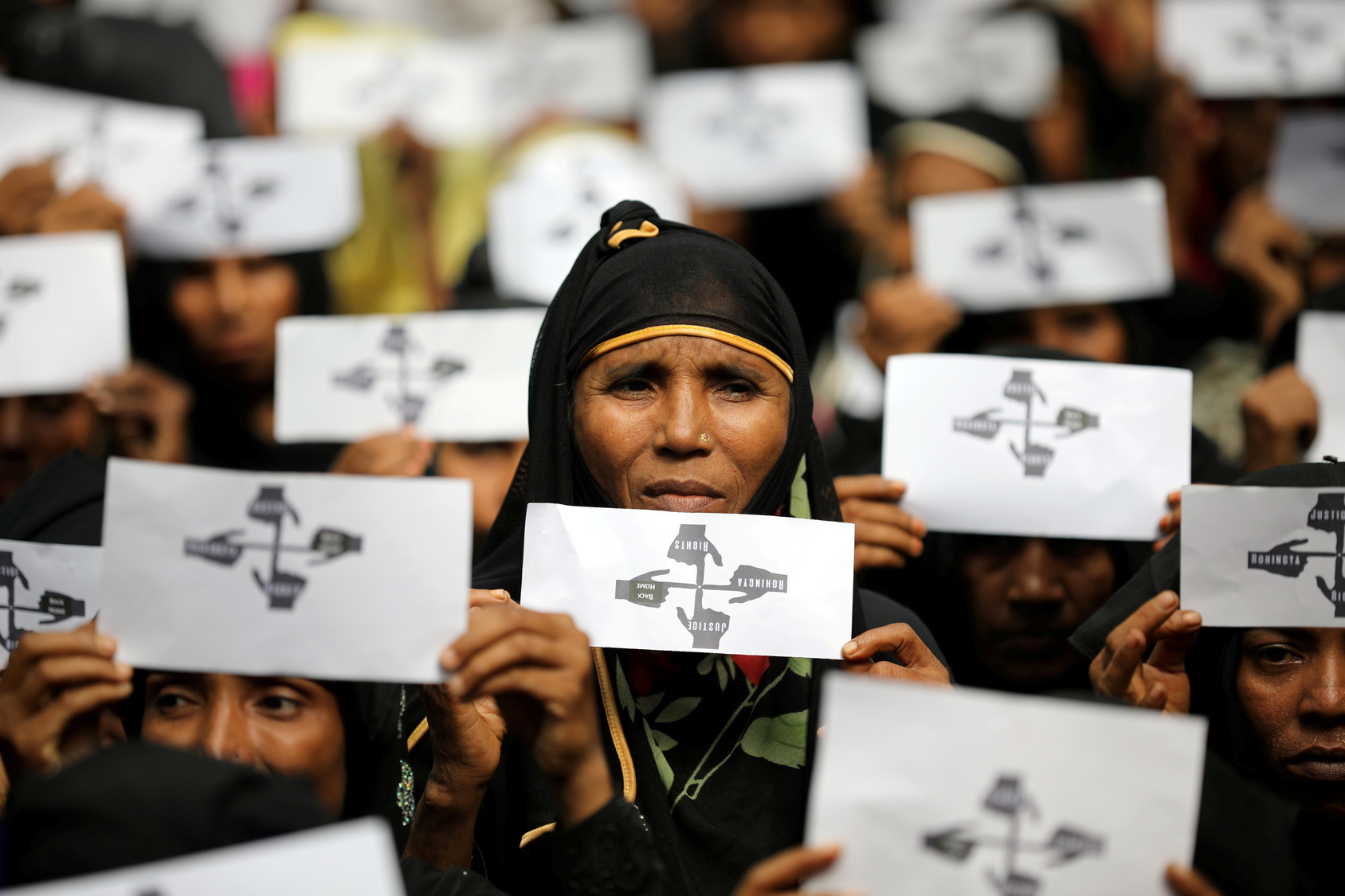 Rohingya refugee women hold placards as they take part in a protest at the Kutupalong refugee camp to mark the one-year anniversary of their exodus in Cox's Bazar, Bangladesh